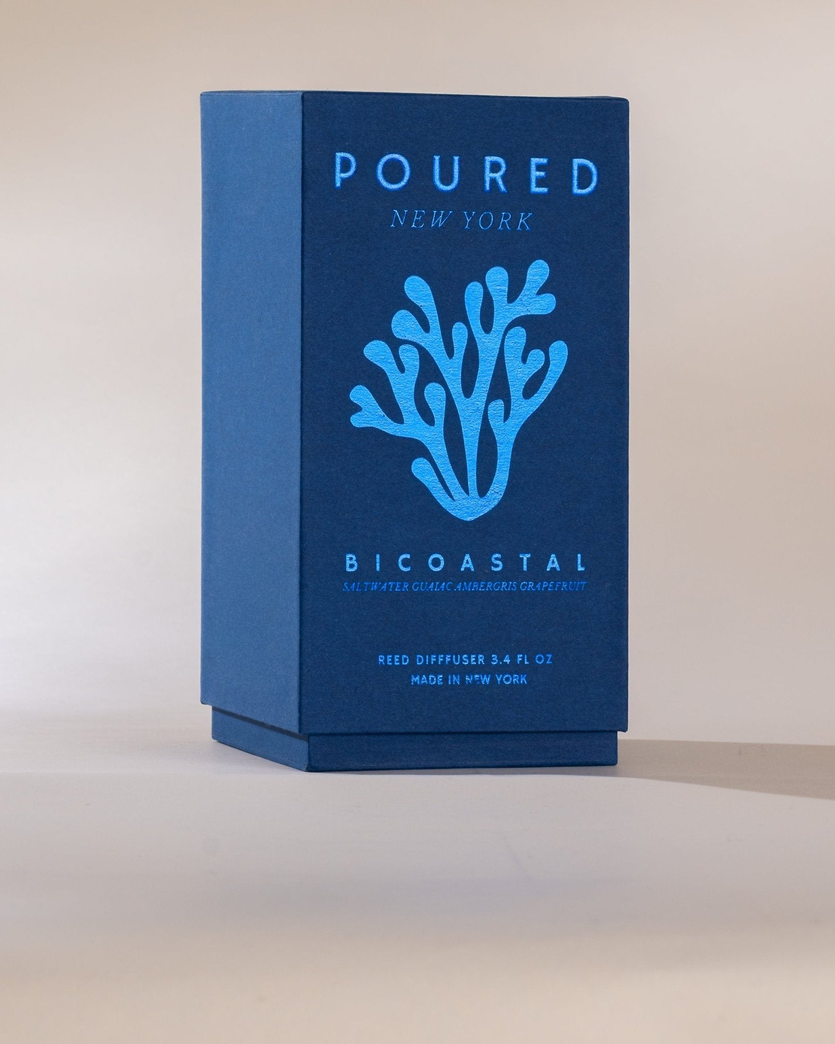 Blue Reed Diffuser packaging box with 'POURED NEW YORK' branding and coral design on a beige background