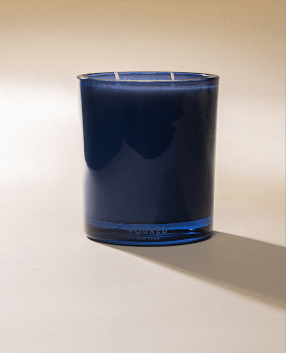 Poured New York 'Bicoastal' two wick blue candle on a beige background