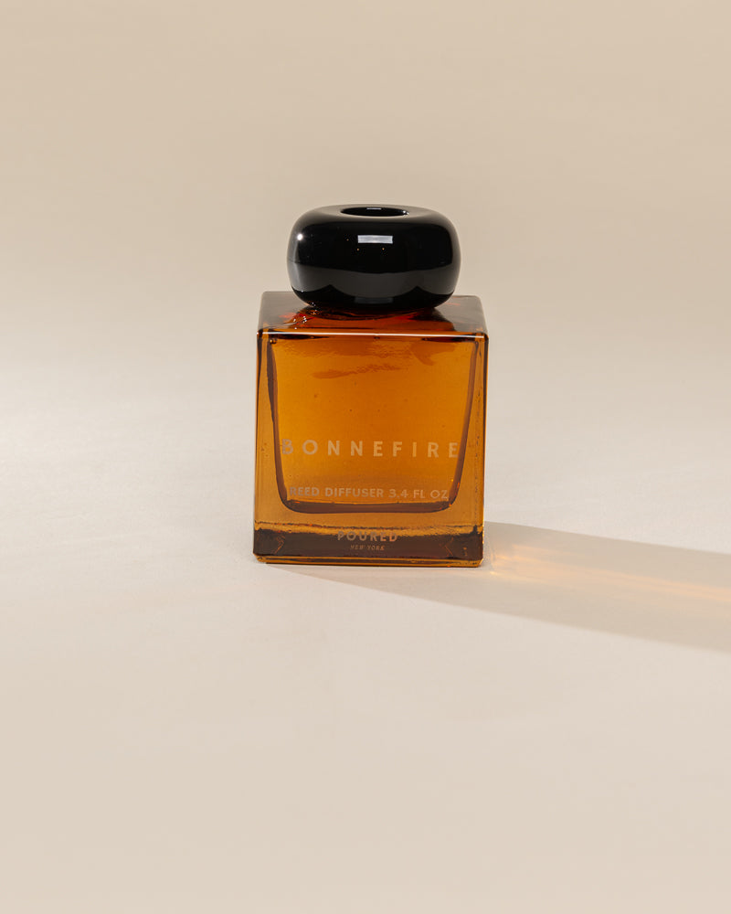 Poured New York 'Bonnefire' reed diffuser on a neutral background