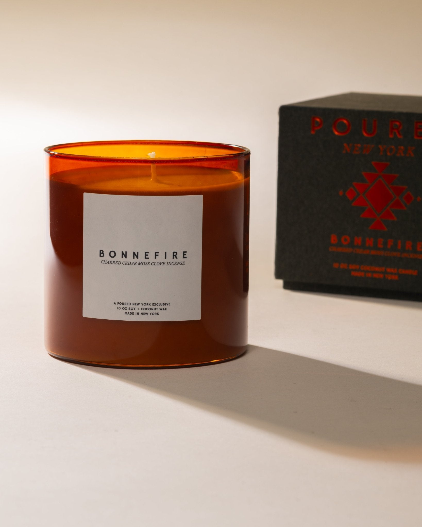Bonnefire candle with an orange transparent container and a 'Poured' box in the background.