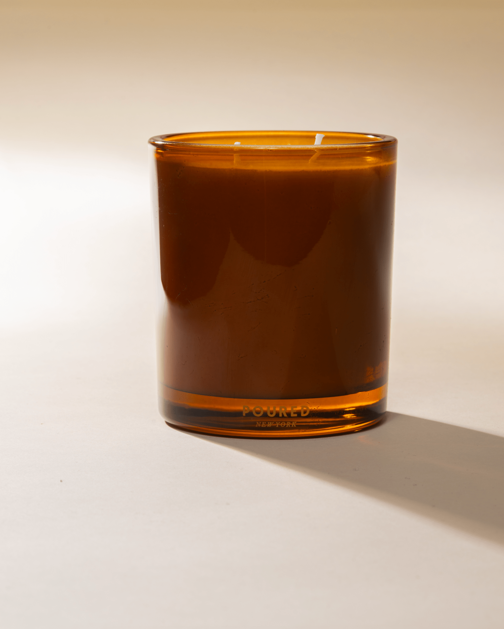 Poured New York 'Bonnefire' Two Wick Soy Coconut wax orange glass candle on neutral background
