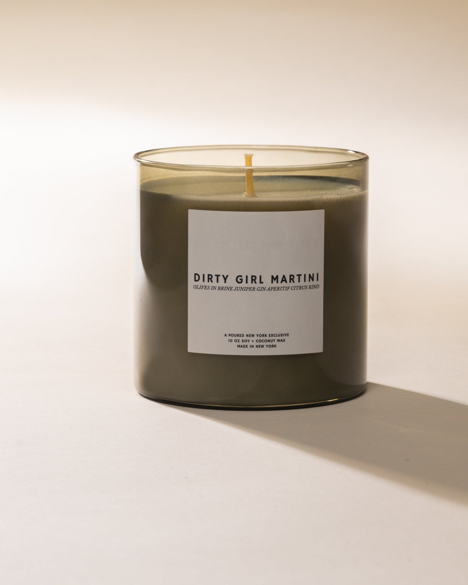 Poured New York 'Dirty Girl Martini' candle in olive green glass on a neutral background