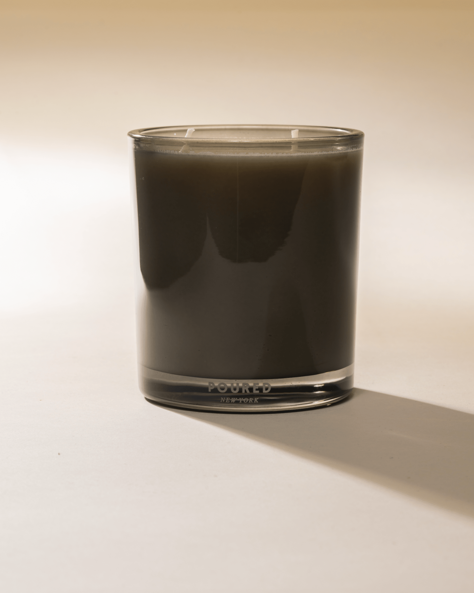 Poured New York 'Dirty Girl Martini' two wick candle in olive green glass on a neutral background
