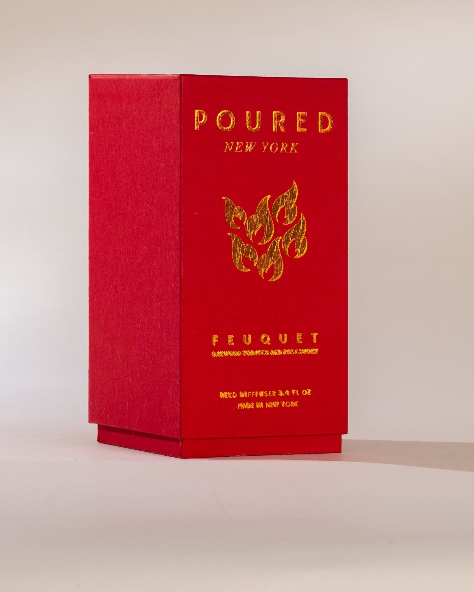 Poured New York ' Feuquet' red reed diffuser box with a flame decal on a neutral background