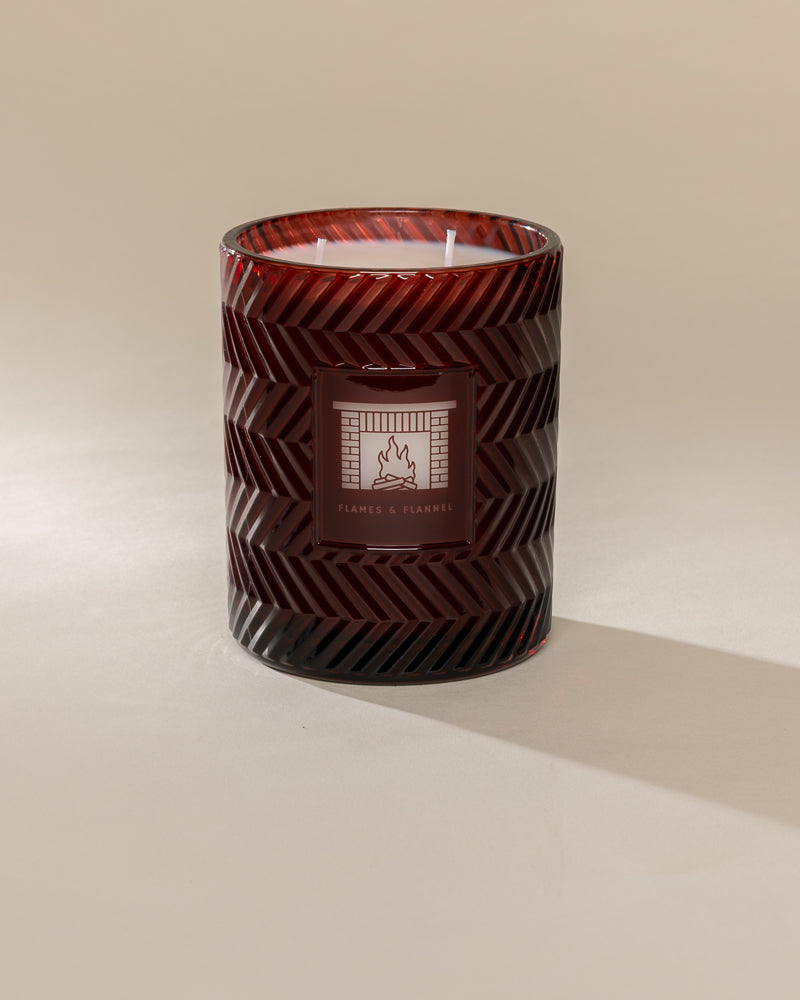 Poured New York 'Flames & Flannel' 22 oz red glass vintage etched double wick candle on a neutral background