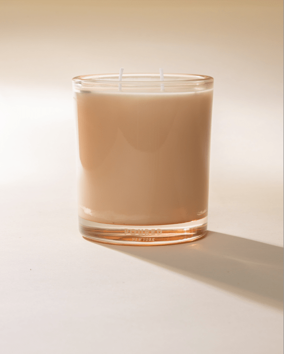 Poured New York Two Wick 'Flesh & Fuzz' candle in a peach glass on a neutral background