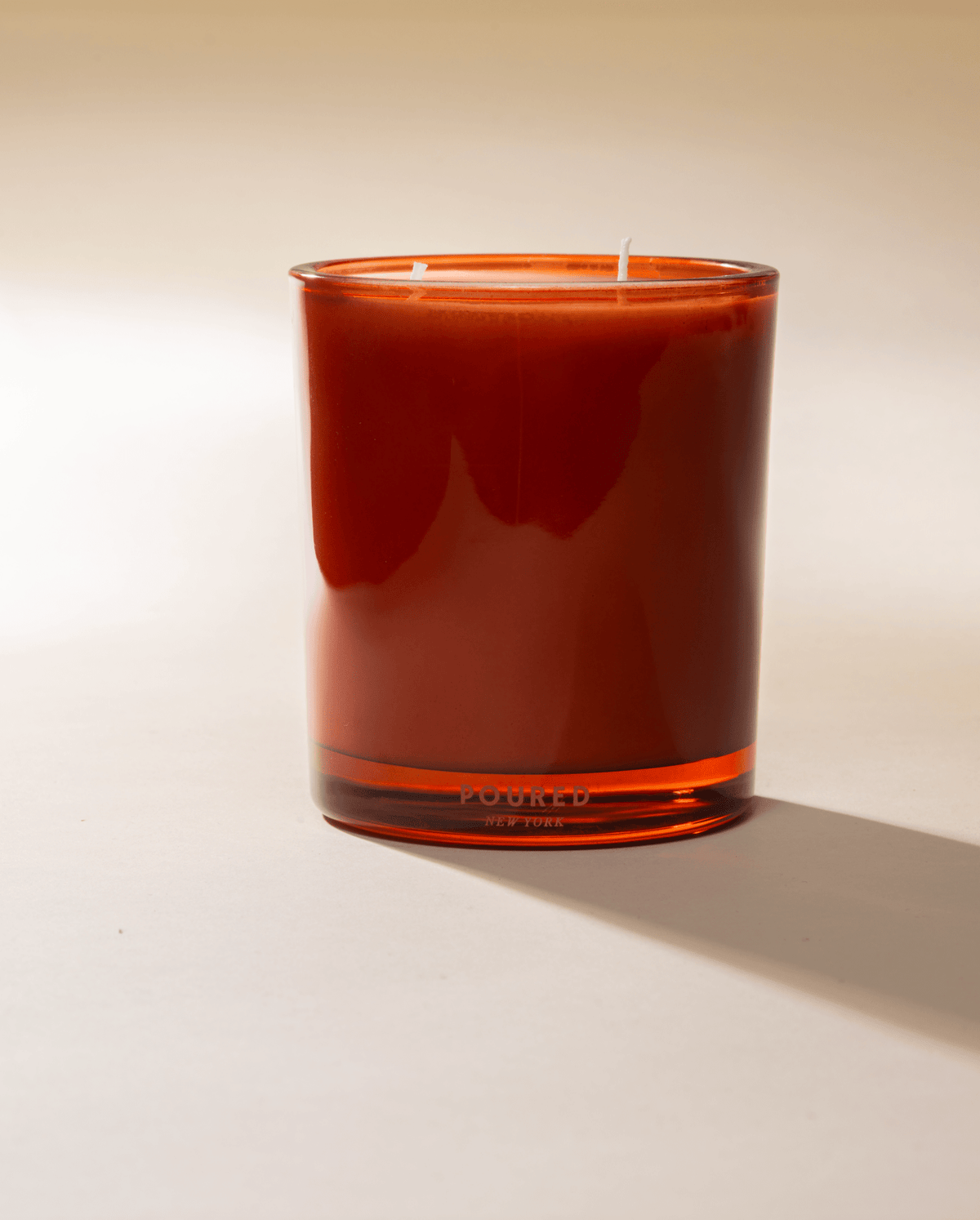 Poured New York 'Indopomodoro' tomato red glass two wick candle on neutral background