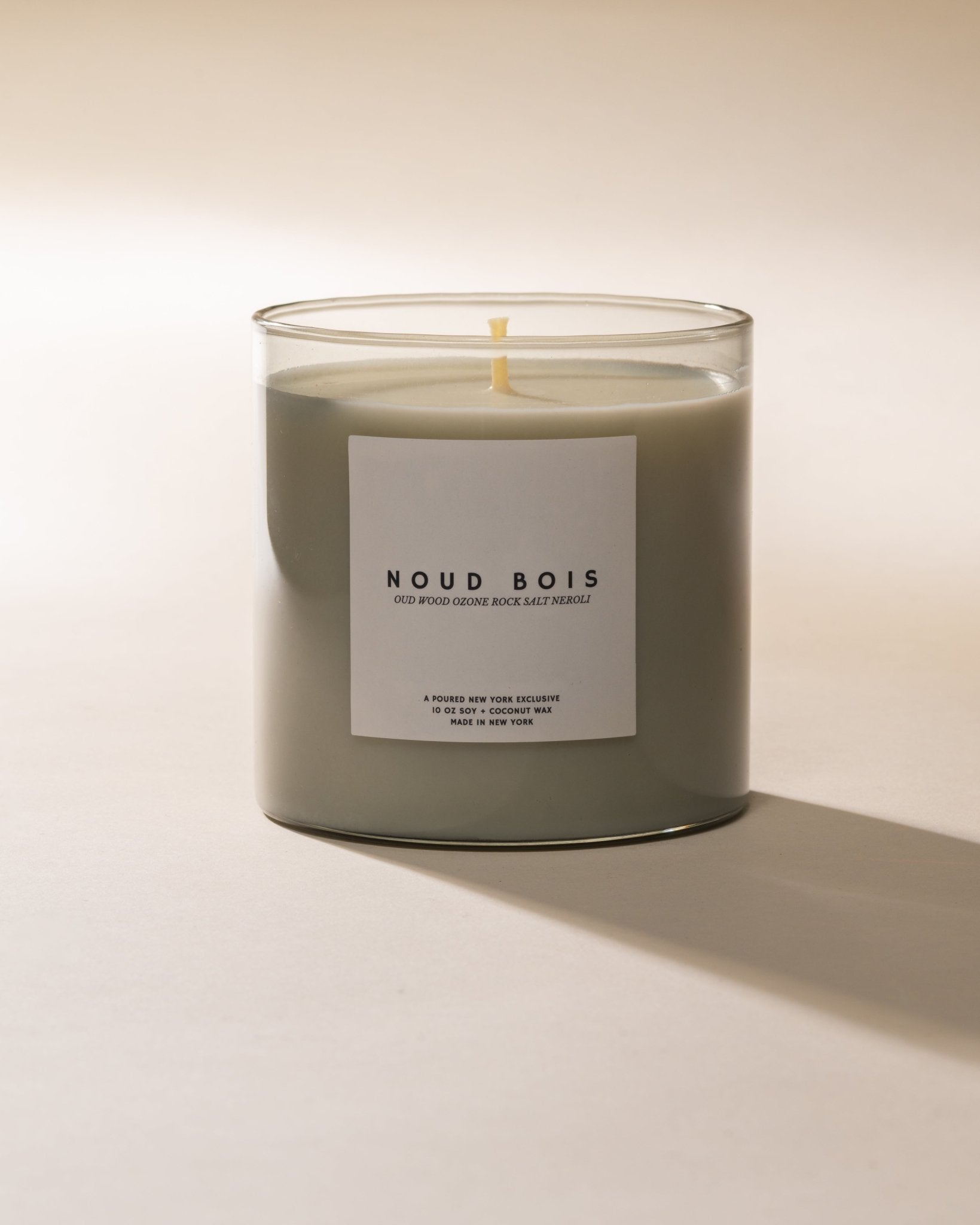 Poured New York 'Noud Bois' candle with white label on a light background.