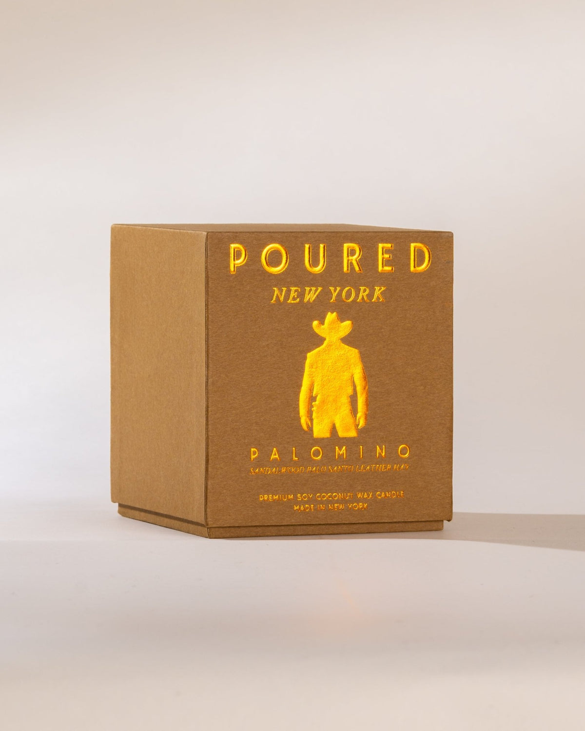 Poured New York 'Palomino' candle box with a cowboy icon on a neutral background