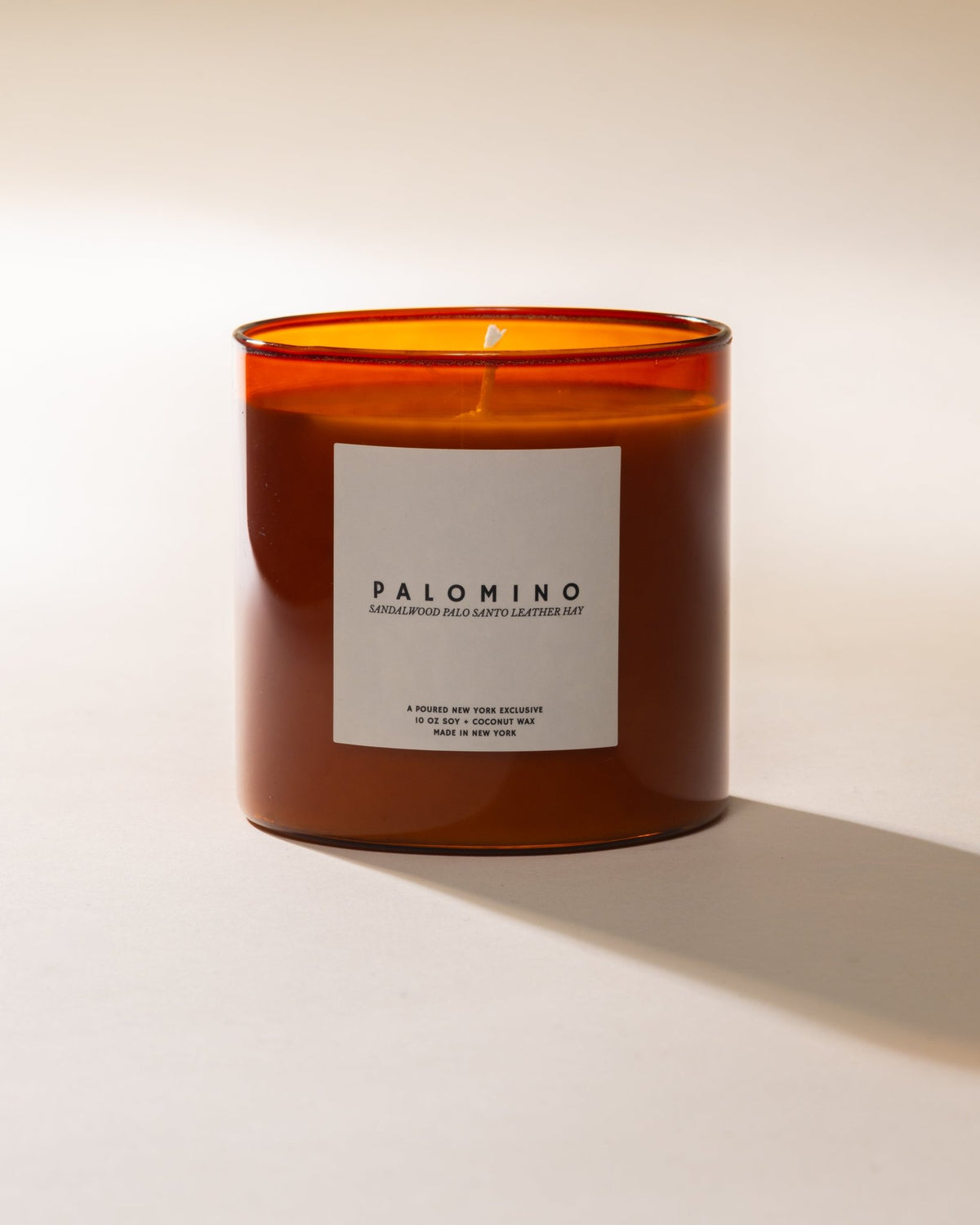 Candle with a 'Palomino' label on a plain background