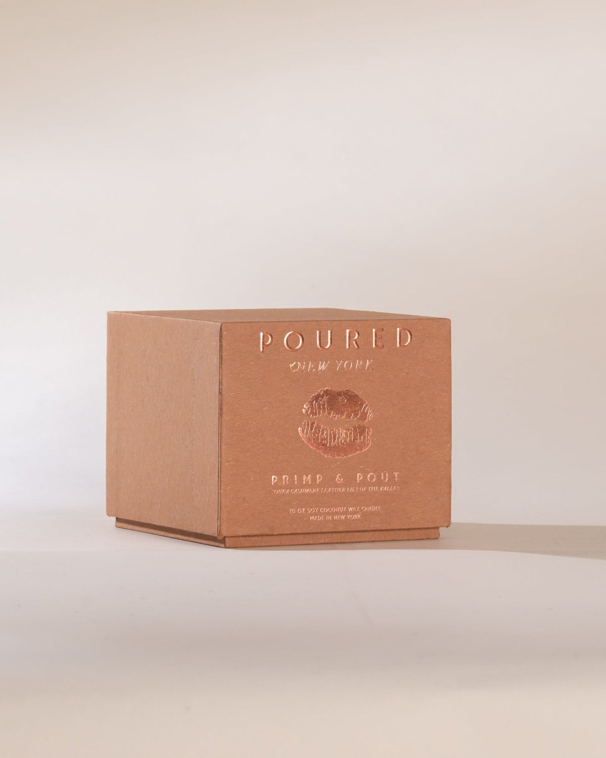 Brown box with 'POURED' branding and pouty lip decal on a beige background