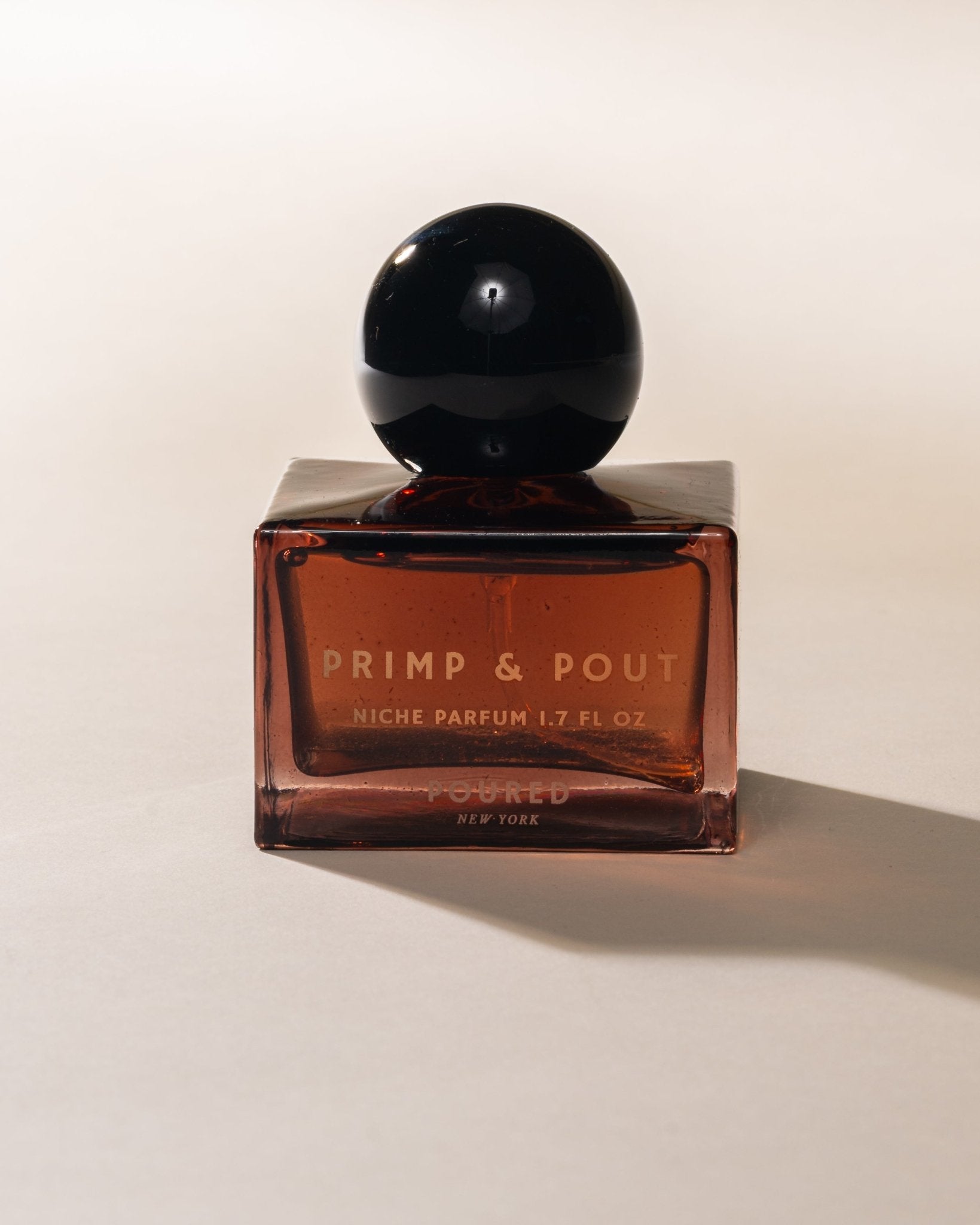 Perfume bottle labeled 'Primp & Pout' on a light background