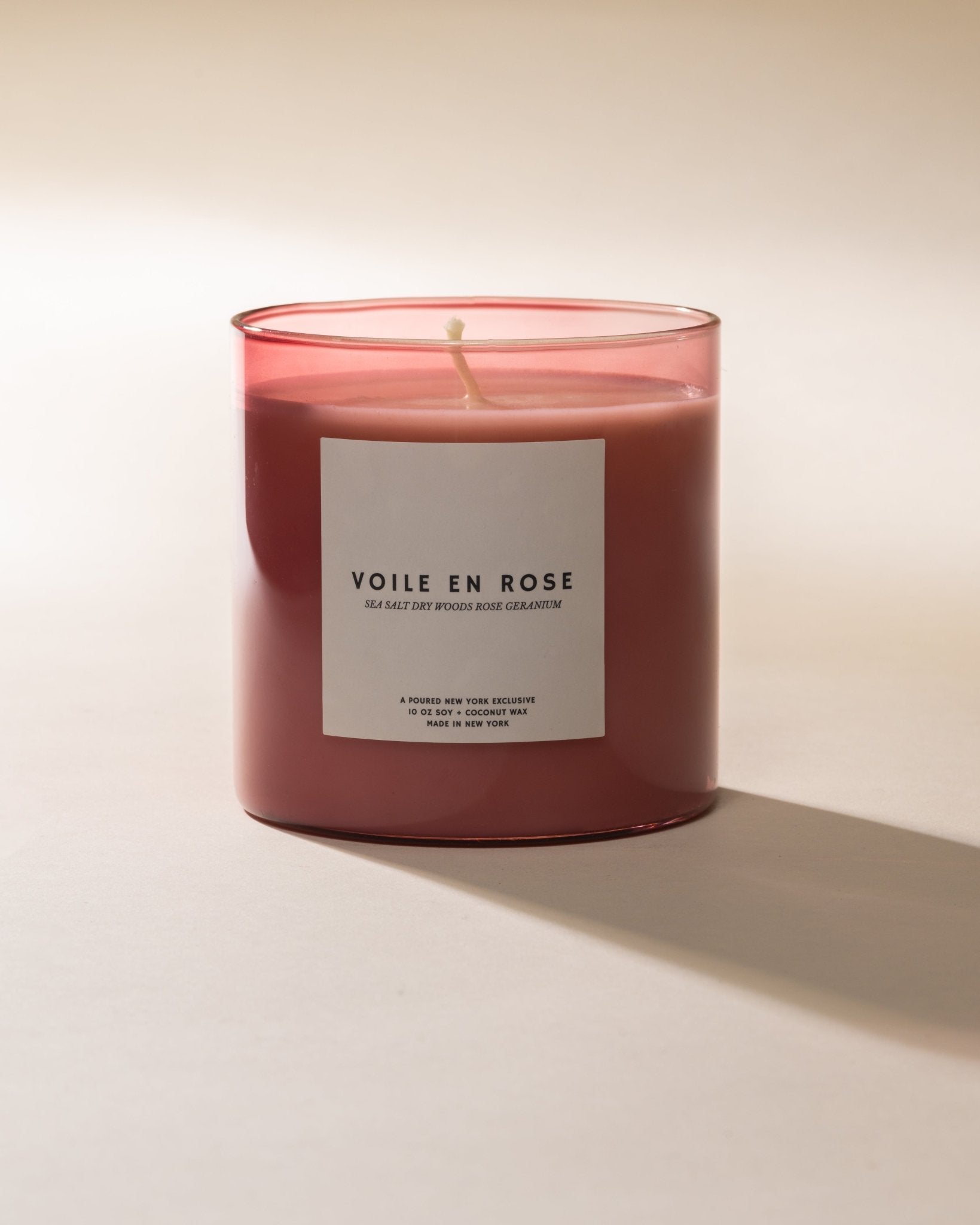 Poured New York 'Voile en Rose' pink glass candle on neutral background