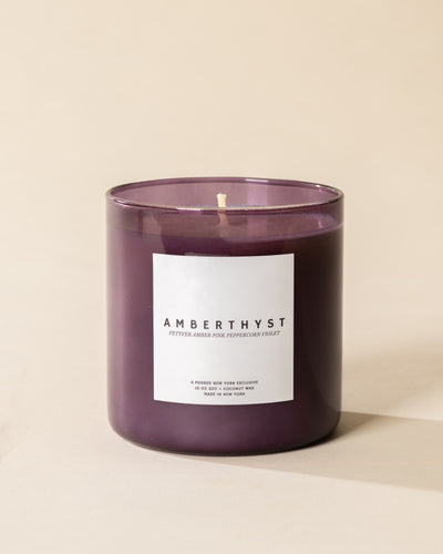 Poured New York 'Amberthyst' 10 oz purple glass soy coconut wax candle on a neutral background