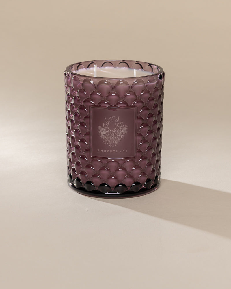 Poured New York 'Amberthyst' 22 oz purple glass vintage etched double wick candle on a neutral background