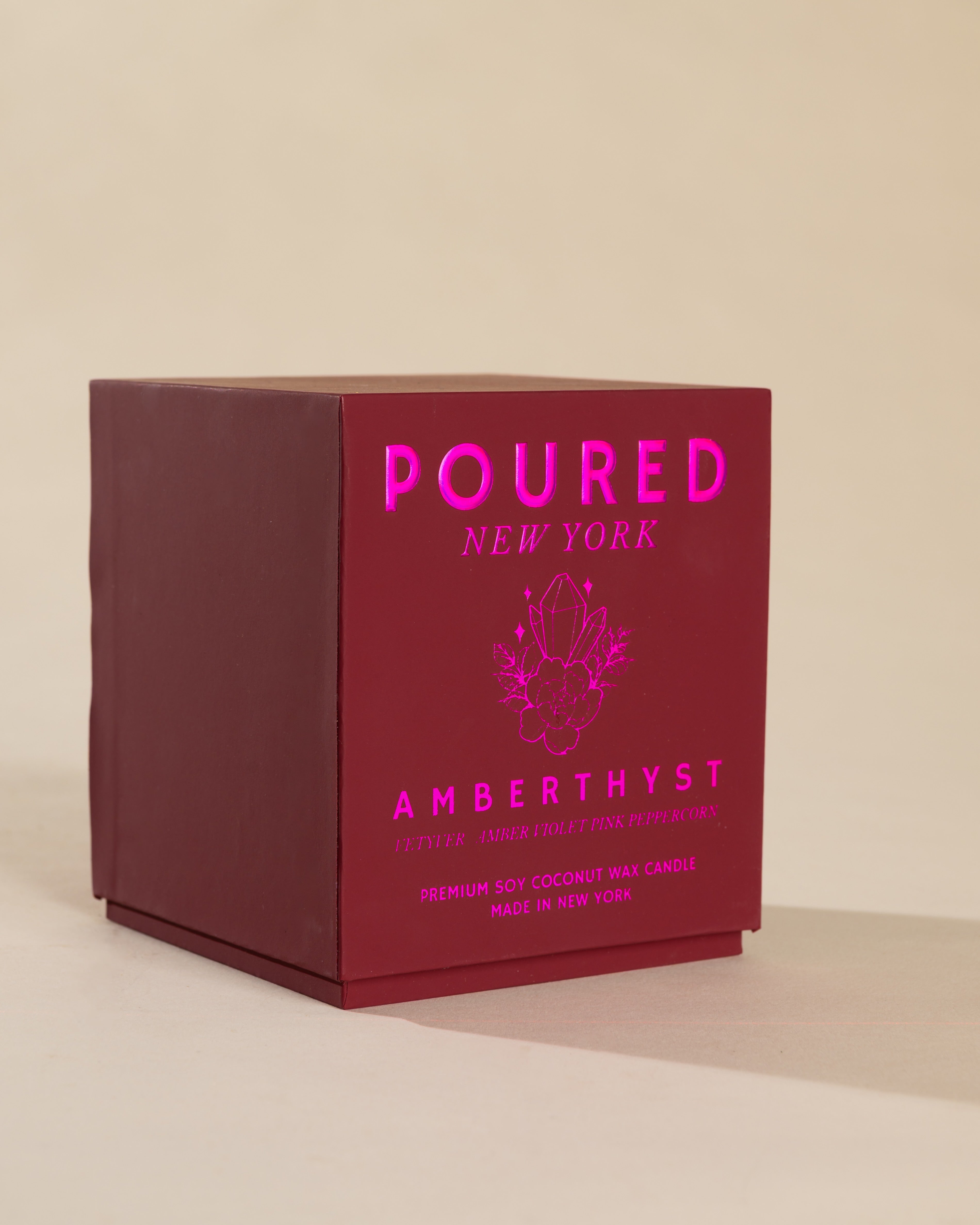 Poured New York 'Amberthyst' candle box packaging on a neutral background