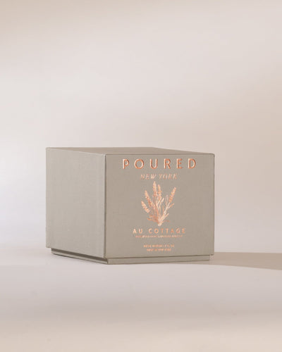 Poured New York 'Au Cottage' grey perfume box and lavender decal on a neutral background