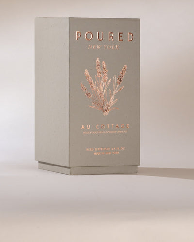 Poured New York 'Au Cottage' grey reed diffuser box and lavender decal on a neutral background