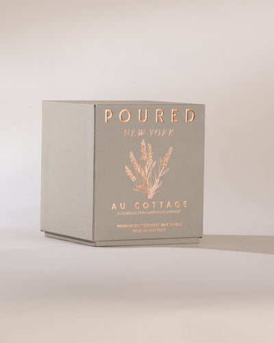 Poured New York 'Au Cottage' grey candle box and lavender decal on a neutral background