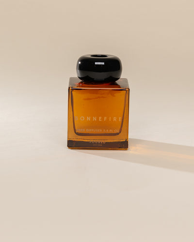 Poured New York 'Bonnefire' reed diffuser on a neutral background