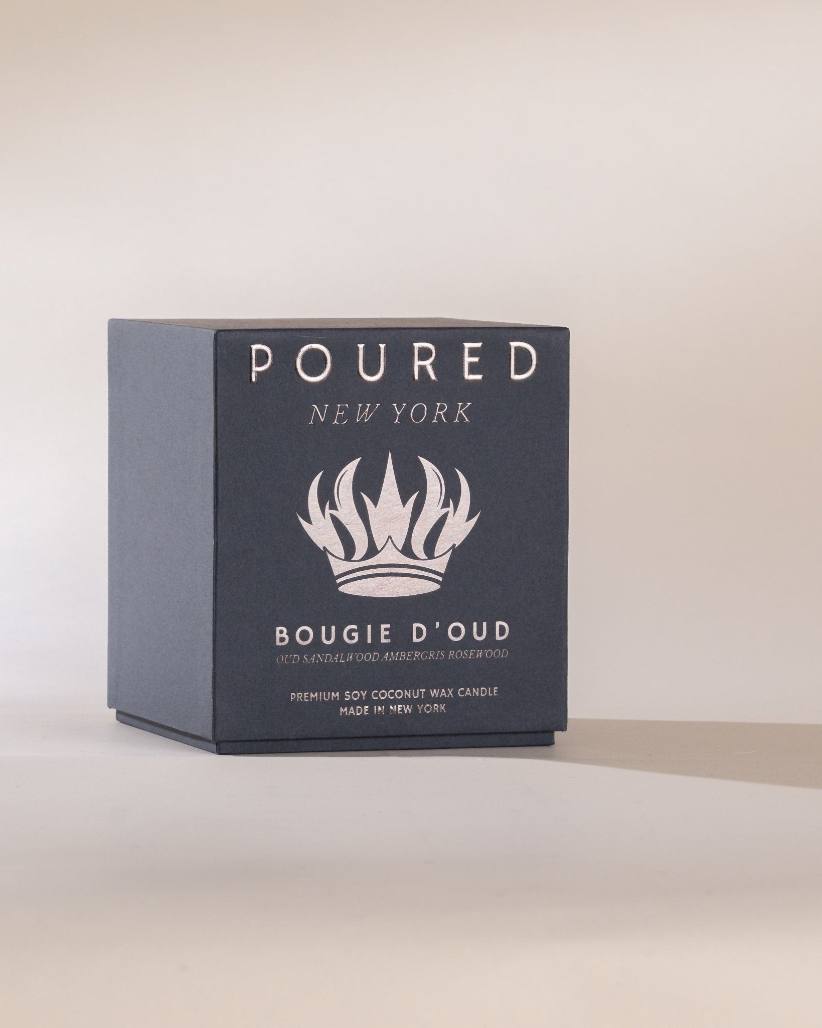 Poured New York 'Bougie D'Oud' candle box on a light beige background