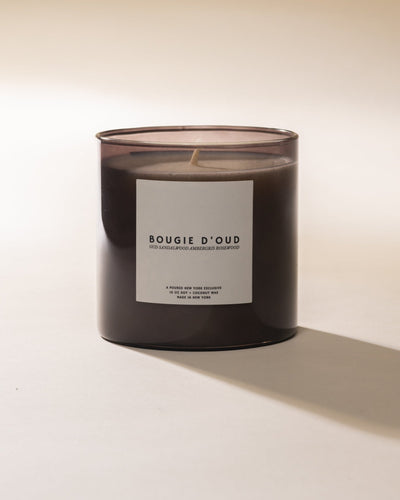 Poured New York 'Bougie D'oud' grey candle on a neutral background
