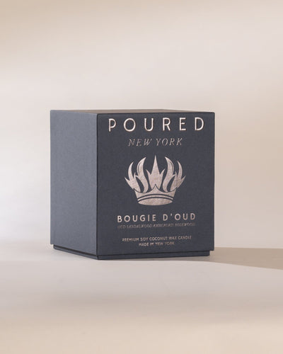 Candle packaging with 'POURED New York' branding and crown decal on a light background