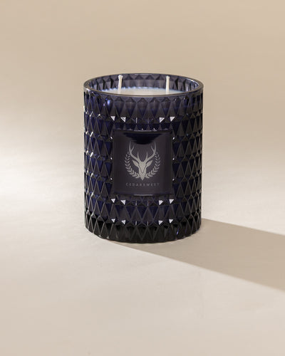 Poured New York 'Cedarsweet' 22 oz navy glass vintage etched double wick candle on a neutral background