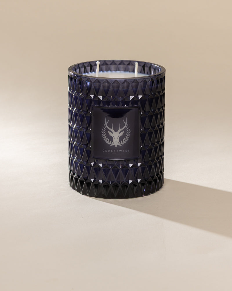 Poured New York 'Cedarsweet' 22 oz navy glass vintage etched double wick candle on a neutral background