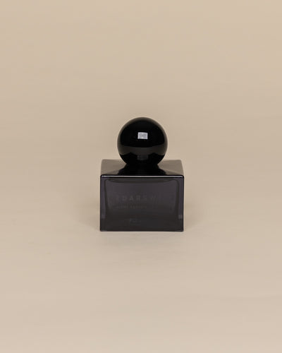 Poured New York 'Cedarsweet' niche parfum in a navy glass bottle on a neutral background