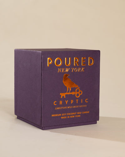 Poured New York 'Cryptic' candle box packaging on a neutral background