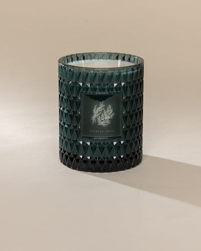 Poured New York 'Cypress Chill' 22 oz teal glass vintage etched double wick candle on a neutral background