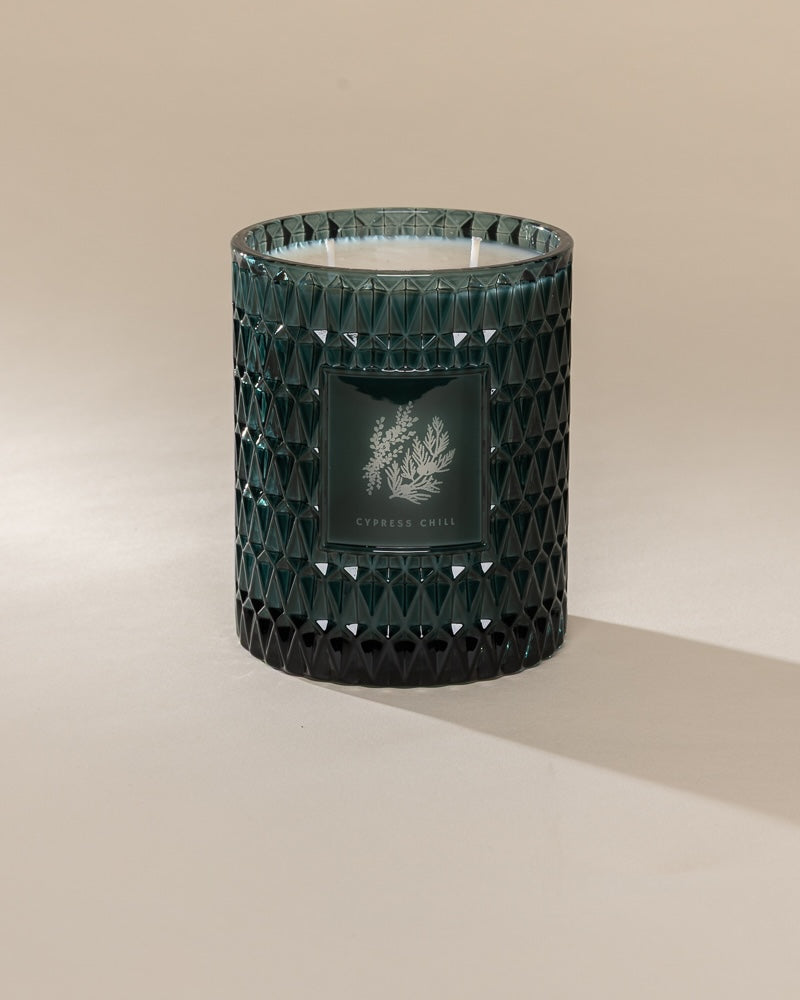 Poured New York 'Cypress Chill' 22 oz teal glass vintage etched double wick candle on a neutral background