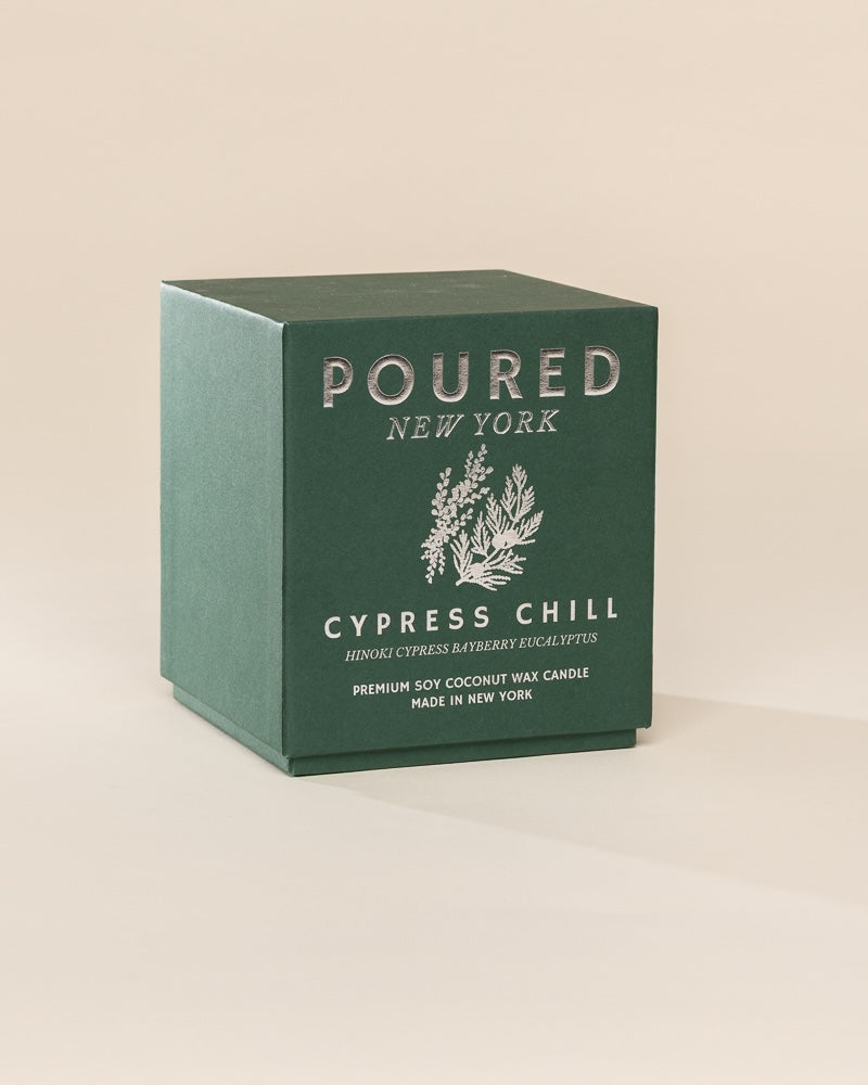 Poured New York 'Cypress Chill' candle box packaging on a neutral background