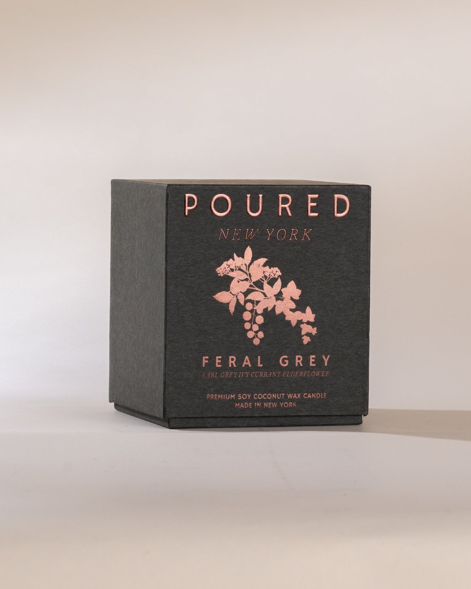 Poured New York 'Feral Grey' grey candle box with an ivy and currant decal on a neutral background.