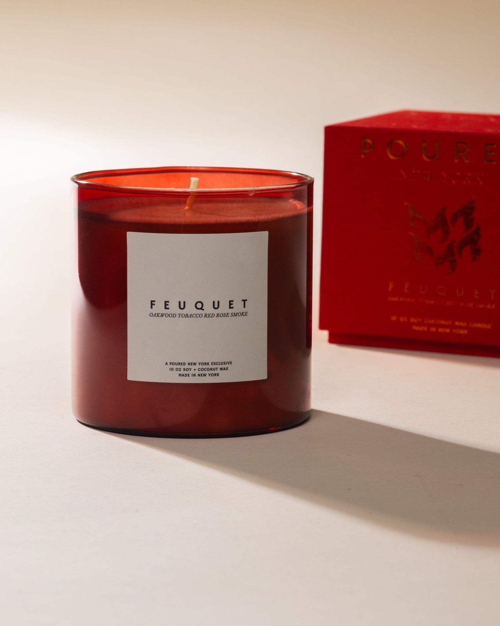 Poured New York ' Feuquet' red candle with matching red box with a flame decal on a neutral background