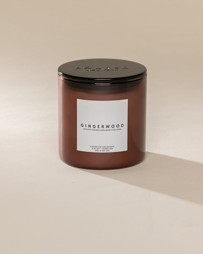 Poured New York 'Gingerwood' brown glass soy coconut wax candle on a neutral background