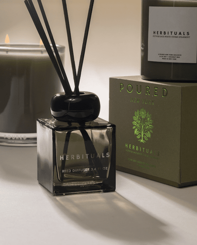 Poured New York 'Herbituals' lifestyle shot with the sage green reed diffuser in the foreground and the two candle options in the background. 