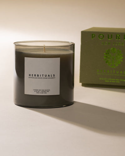 Poured New York 'Herbituals' sage green candle with a matching box on a neutral background