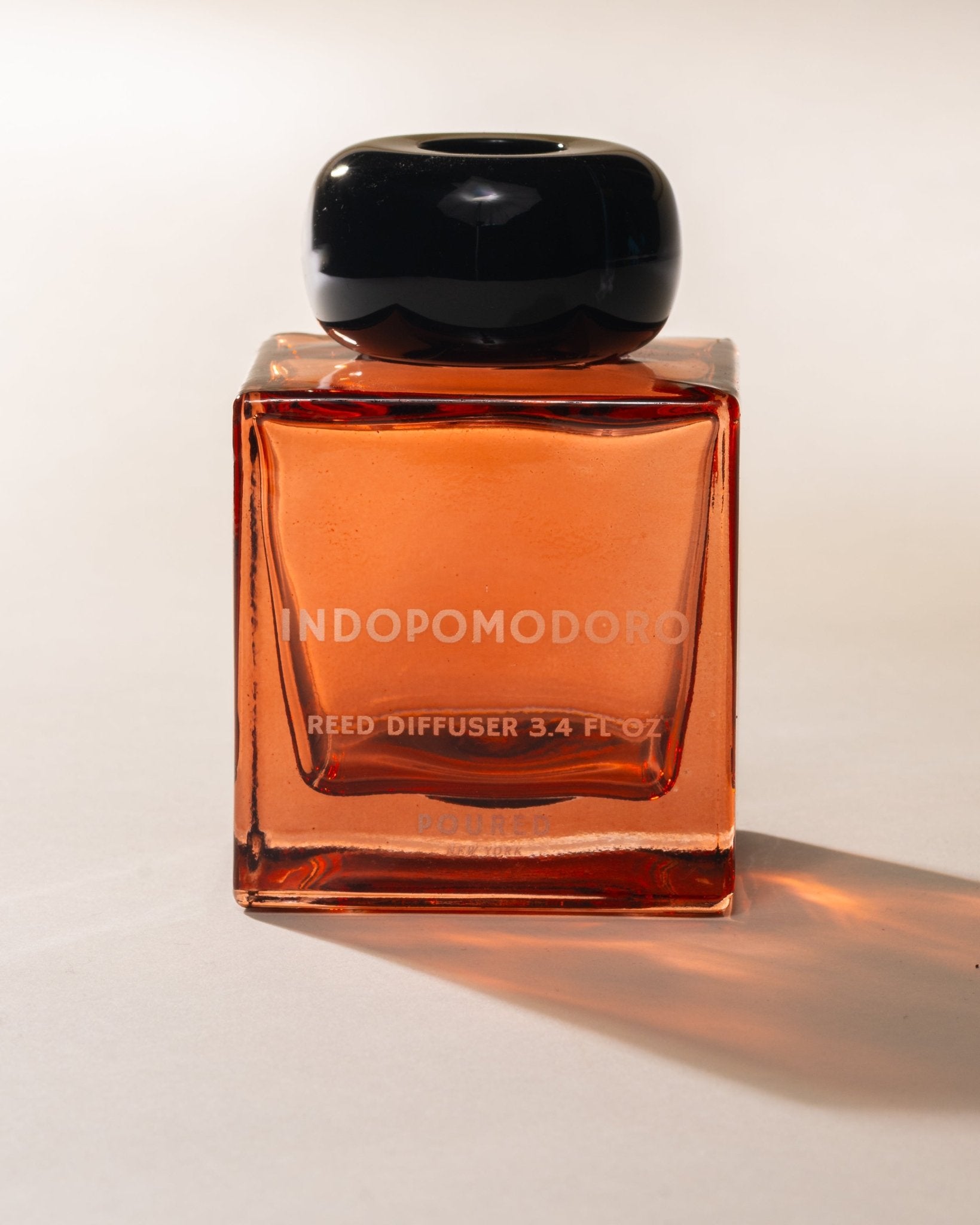 Indomodoro reed diffuser with a black cap on a white background
