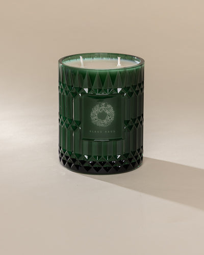 Poured New York 'Klaus Haus' 22 oz green glass vintage etched coconut soy wax candle on a neutral background
