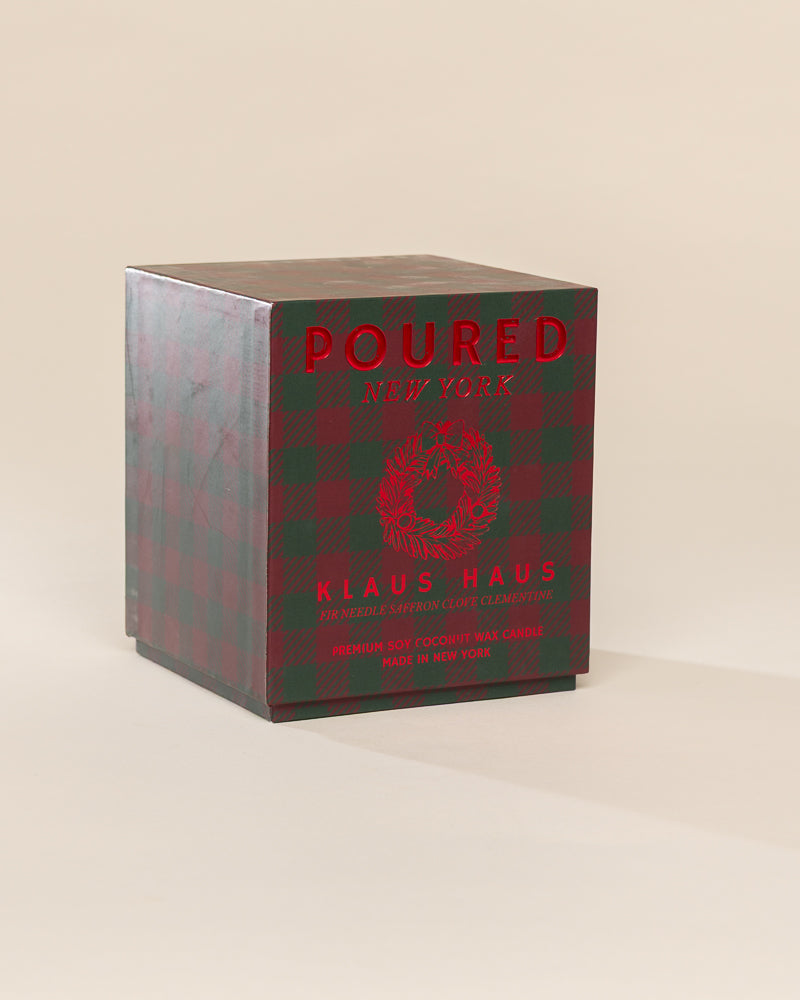 Poured New York 'Klaus Haus' candle box packaging on a neutral background