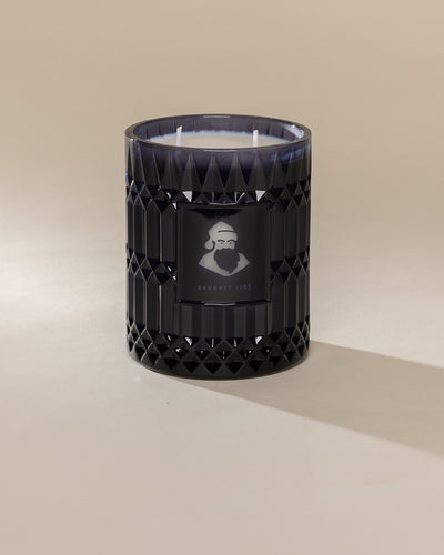 Poured New York 'Naughty List' 22 oz navy glass vintage etched double wick candle on a neutral background
