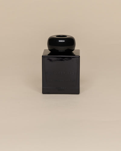 Poured New York 'Naughty List' 3.4 fl oz reed diffuser in a navy glass vessel on a neutral background