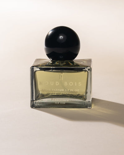 Poured New York 'Noud Bois' Niche Parfum square bottle with black circular cap on neutral background