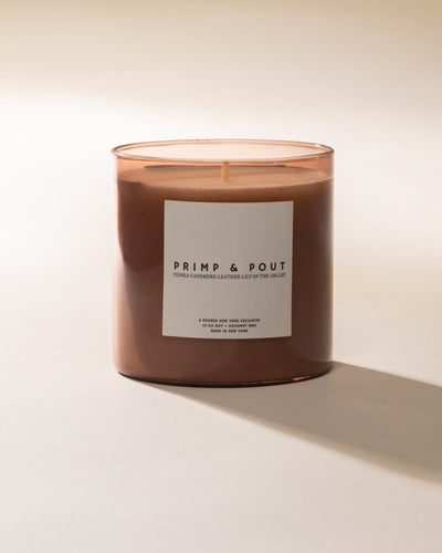 Candle with a 'Primp & Pout' label on a light background
