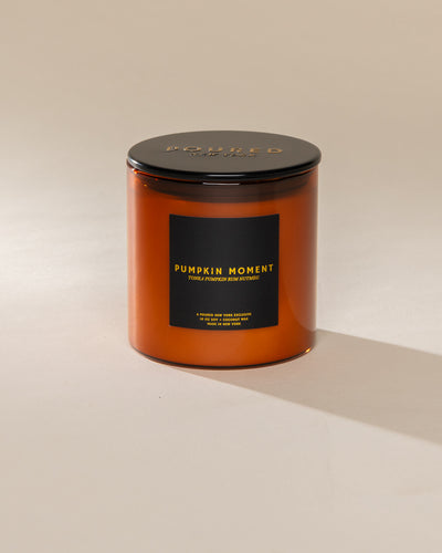 Poured New York 'Pumpkin Moment' 10 oz orange glass soy wax candle on a neutral background