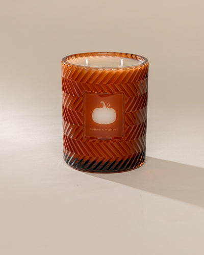 Poured New York 'Pumpkin Moment' 22 oz orange glass vintage etched candle on a neutral background