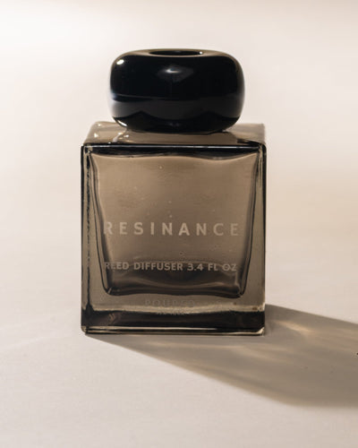 Poured New York 'Resinance' sage green square glass reed diffuser with black cap on neutral background