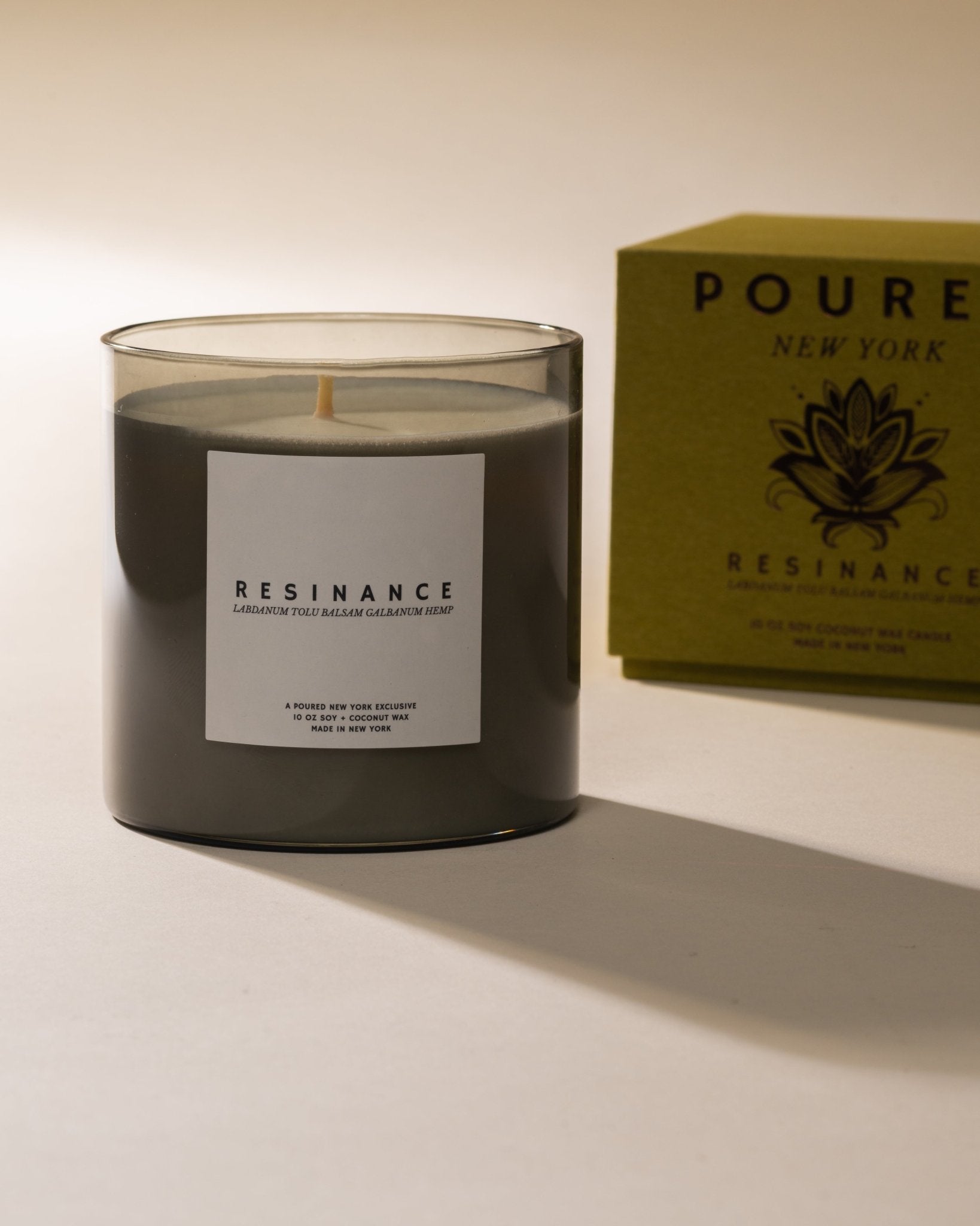Poured New York 'Resinance' sage green candle and matching candle box with floral decal on neutral background.